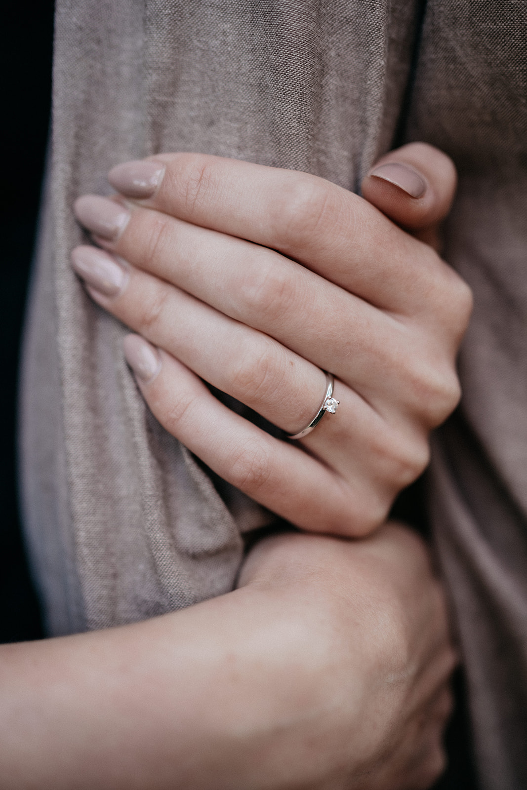 Detailaufnahme eines Verlobungsrings beim Paarshooting in Ahaus, Hand liebevoll am Arm des Partners.