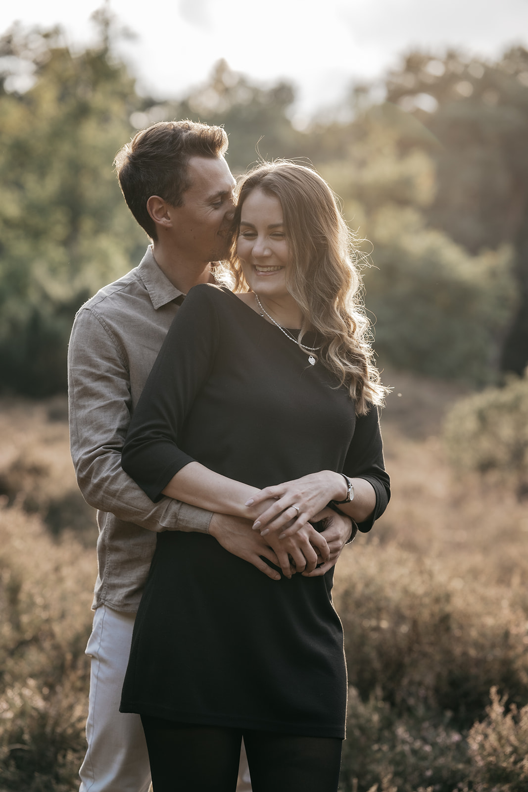 Glückliches Paar beim Paarshooting in Ahaus, innige Umarmung in der Natur bei warmem Abendlicht.