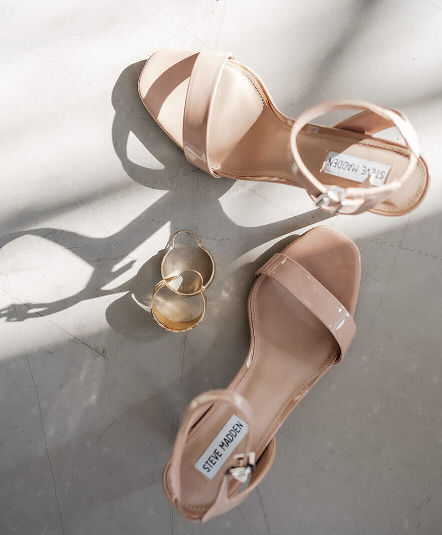 Beige Brautsandalen und goldene Ohrringe im Sonnenlicht – Hochzeitsfotograf Ahaus.