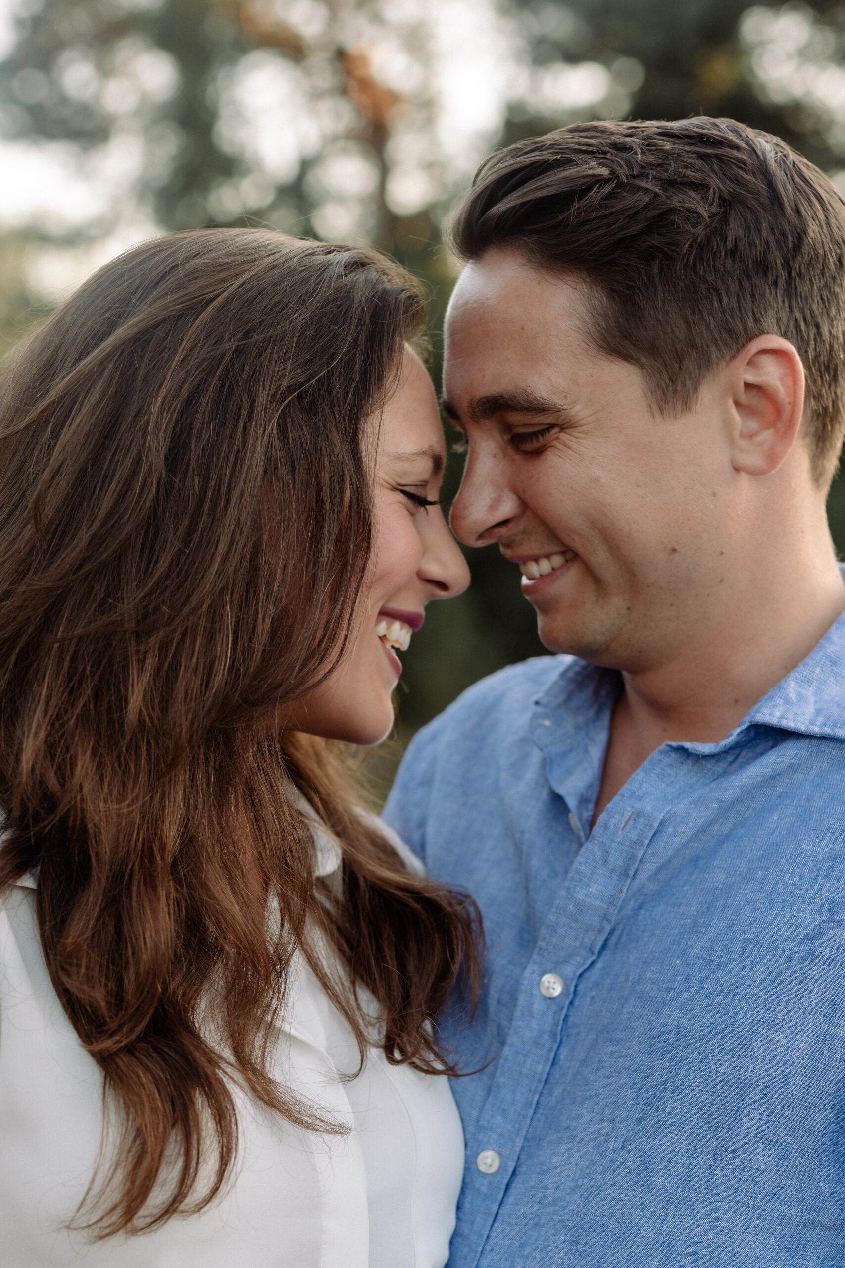 Verliebtes Paar beim Paarshooting in Ahaus, lächelnd mit den Stirnen aneinander gelehnt in der Natur.