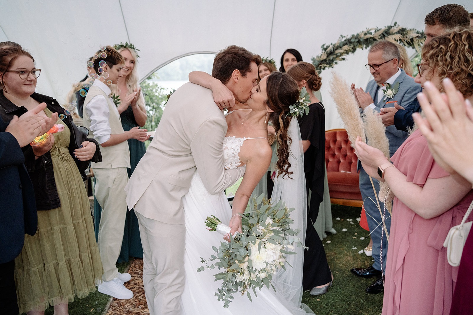 rautpaar küsst sich unter Jubel der Gäste bei freier Trauung – Hochzeitsfotografie Ahaus