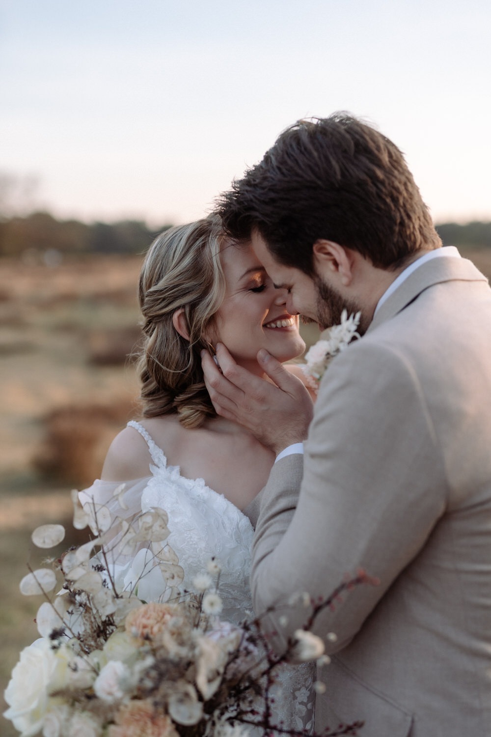 Brautpaar küsst sich innig bei natürlicher Hochzeitsreportage im Abendlicht.